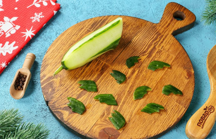 1. Этап. Закуска Дракончики на Новый год 2024: У огурца при помощи овощечистки снимите шкурку и вырежьте при помощи кухонных ножниц крылья. Наша закуска почти готова. поместите головы драконов поверх икры, вставьте в сырно-яичную массу крылышки и украсьте так, чтобы без труда можно было догадаться, что это именно дракончики.