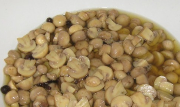 1. Этап. Быстрое маринование шампиньонов: Приготовим маринад. Кипятим в кастрюле воду и уксус. Добавляем соль, перец и специи. В кипящий маринад опускаем грибы, снова доводим до кипения, удаляя пену. Варим еще 25 минут. Кастрюлю снимаем с плиты и сразу же ставим в таз с холодной водой, чтобы быстро охладить грибочки.