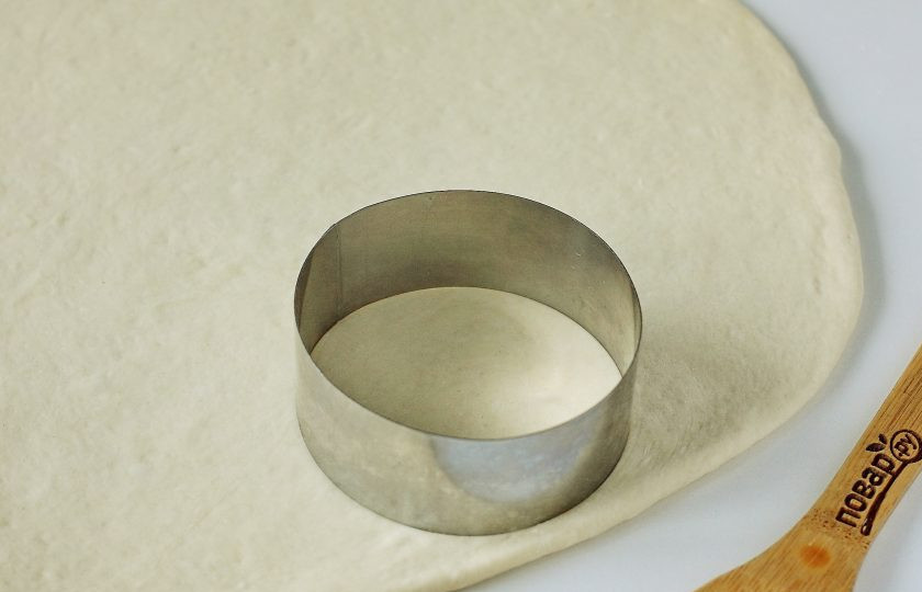 1. Этап. Дрожжевые пышки на сковороде: Тесто нужно обмять и на присыпанной мукой поверхности раскатать в пласт, толщиной 1-1,5 см. Металлической вырубкой или обычным стаканом вырежьте круглые заготовки желаемого размера.