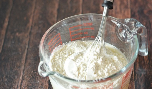 1. Этап. Сочный пирог с консервированными персиками: Добавьте муку и разрыхлитель и тщательно вмешайте её, чтобы не было комков.