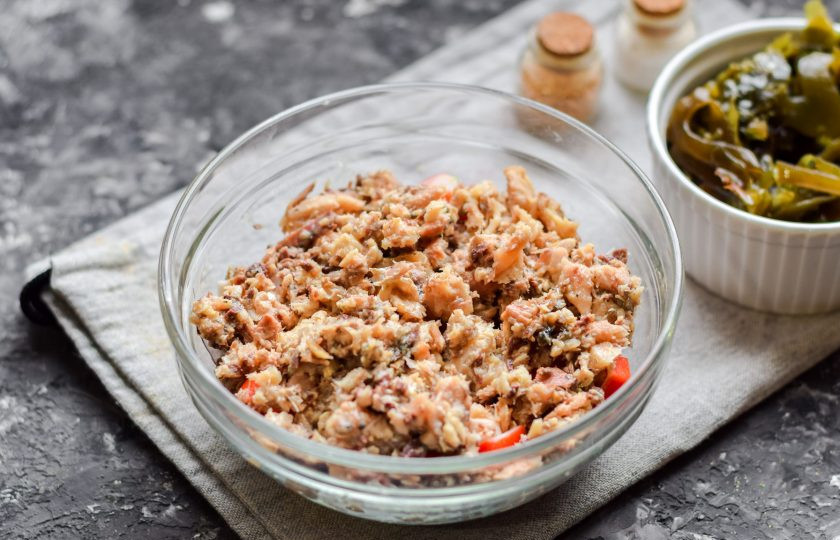 1. Этап. Салат Морское дно с морской капустой: Поверх крабовых палочек разложите рыбные консервы, размятые предварительно вилкой.