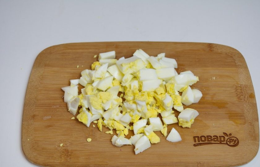 1. Этап. Салат 8 Марта с кальмарами: Отварные куриные яйца необходимо очистить и нарезать кубиком.