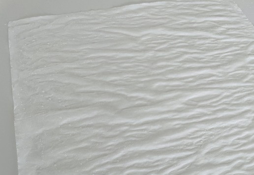 1. Этап. Козинаки «Микс»: Готовим лист бумаги для выпечки. Смачиваем его под проточной водой, разравниваем на ровной поверхности и рукой растираем по нему ложку растительного масла без запаха.