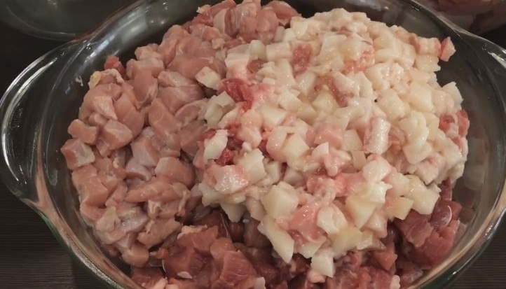 1. Этап. Вкусные и сочные домашние колбаски: 2. Вторую половину мяса нарежьте небольшими кубиками, а сало — кубиками еще меньшего размера. 2 зубчика чеснока выдавите в мясо.