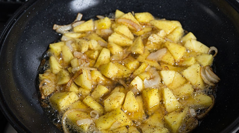 1. Этап. Плов в духовке со свининой: Извлекаем ананасы из банки и нарезаем кубиками. Добавляем их к луку, который начинает золотится. Жарим вместе, пока кухню не наполнит яркий фруктовый аромат.