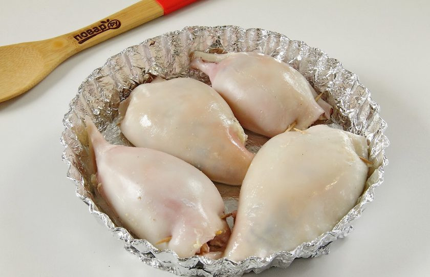 1. Этап. Фаршированные кальмары: 9. Тушки кальмаров наполните начинкой, края скрепите зубочисткой и выложите их в форму для запекания. Я застилаю форму фольгой, но это не обязательно. Дно в любом случае смажьте растительным маслом.