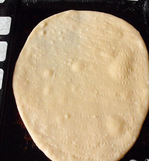 1. Этап. Пицца с колбасой: 2. Раскатываем корж, противень смазываем маслом, и выкладываем на него раскатанное тесто. Возьмем вилку, и наколем ею корж. Ставим противень в духовку, и десять минут выпекаем корж, огонь должен быть большим. Поверхность должна стать слегка прозрачной.