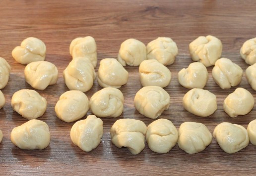 1. Этап. Булочки-трубочки с творогом и повидлом: 9. Разрезаем валики на 36 частей и округляем. Складываем заготовки на разделочную доску и накрываем салфеткой, чтобы тесто не обветрилось.