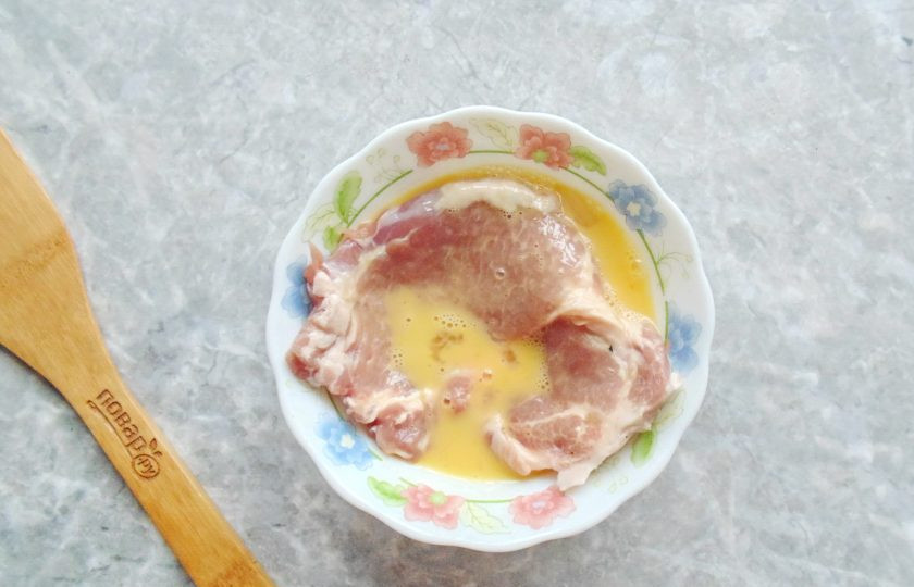 1. Этап. Шницель из свинины с яблоком: Окуните полностью шницель во взбитое яйцо.