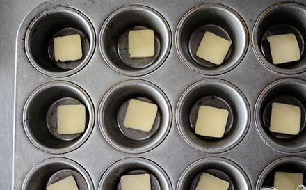 1. Этап. Картофель с сыром и зеленым луком: 2. Достать форму для маффинов или булочек с отделениями. Поместить в каждое отделение кусочек сливочного масла.