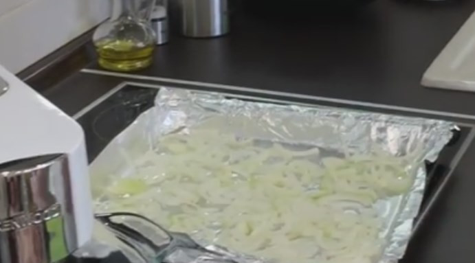 1. Этап. Куриная грудка под кабачками: 1. Застелите противень фольгой. Выложите на него подушку из лука, нарезанного кольцами или полукольцами.