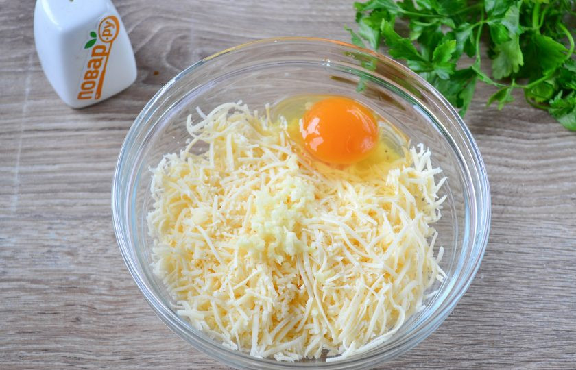 1. Этап. Сырные шарики во фритюре: Выдавите зубчик чеснока через пресс, разбейте яйцо и перемешайте до однородной массы. Посолите по вкусу.