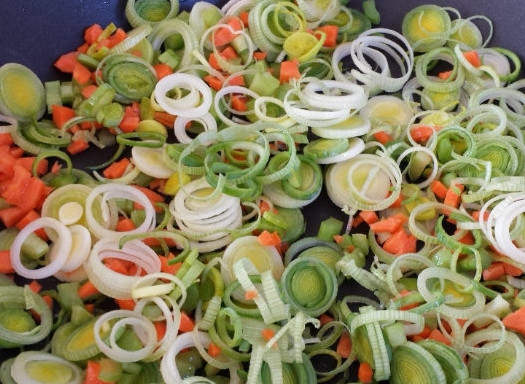 1. Этап. Постный грибной суп из замороженных грибов: 1. В большой сковороде или в сотейнике обжарим измельченный лук-порей, морковь, сельдерей, лавровый лист и измельченный чеснок. Отдельно кипятком заливаем замороженные грибы, чтобы разморозились быстрее.