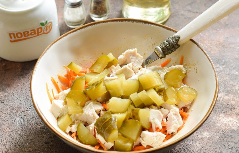 1. Этап. Салат с корейской морковью и маринованными огурцами: Маринованные огурцы нарежьте небольшими кубиками. Добавьте огурцы в салат.