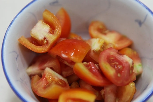 1. Этап. Жареная говядина с овощами: 6. Помидоры промойте, разрежьте вдоль наполовину, потом - дольками.