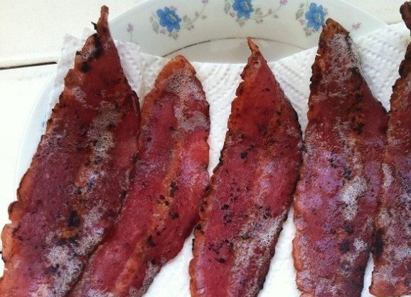 1. Этап. Картофельные оладьи с беконом: 3. Тем временем разрежьте ломтики бекона пополам. Обжарьте их на разогретой сковороде до хрустящей корочки.