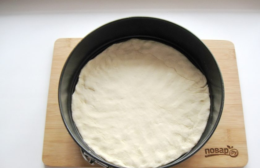 1. Этап. Самая вкусная пицца: Тесто для пиццы раскатайте в пласт диаметром 26-28 см. Выложите в форму для выпекания.