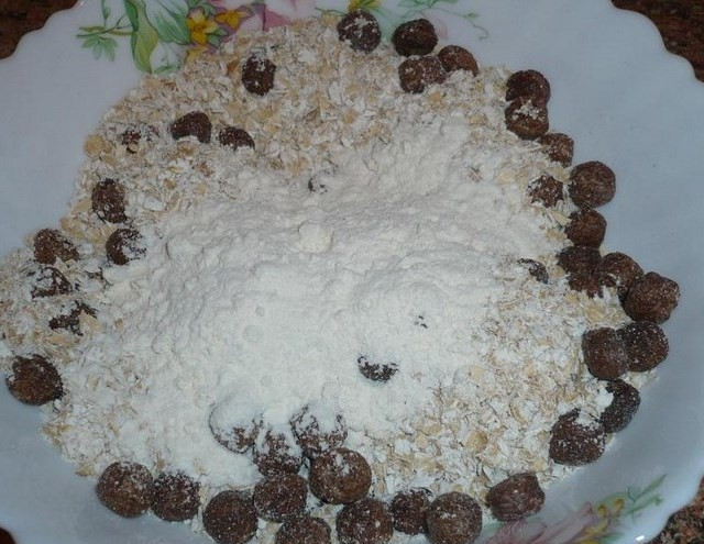 1. Этап. Овсяно-яблочное печенье: 2. Соедините вместе измельченную овсянку, муку, разрыхлитель и шоколадные шарики. Перемешайте.