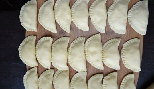 1. Этап. Вареники с сыром сулугуни: 6. Выложите в центр начинку и плотно залепите края. Удобно делать это вилкой, но вы также можете залепить их косичкой, например.