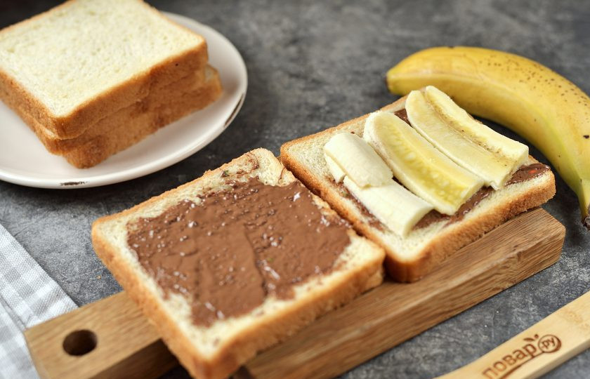 1. Этап. Горячие сэндвичи с шоколадом: Тостовый хлеб смажьте растопленным шоколадом, на одну половину выложите ломтики банана, сложите сэндвич.