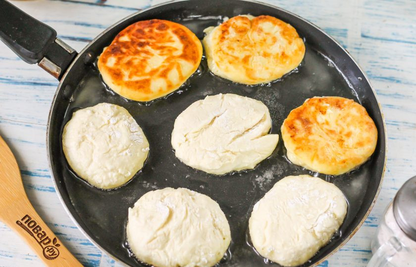 1. Этап. Сырники из козьего творога: Прогрейте на сковороде растительное масло. От теста отщипните часть, сформируйте заготовку наподобие котлеты и обпанируйте в муке на тарелке со всех сторон. Выложите заготовки в масло и обжарьте на умеренном нагреве до румяности, затем переверните на другую сторону.