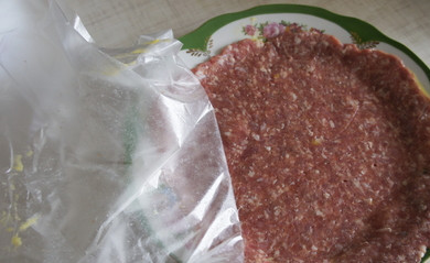 1. Этап. Бризоль с сыром: Снимаем с мясной лепешки верхний слой целлофана и кладем лепешку мясом вниз в мисочку с яичной массой. Снимаем оставшийся целлофан.