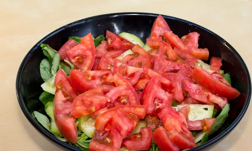 1. Этап. Легкий салат с курицей: Помидоры нарезаем произвольно и добавляем в салатницу.