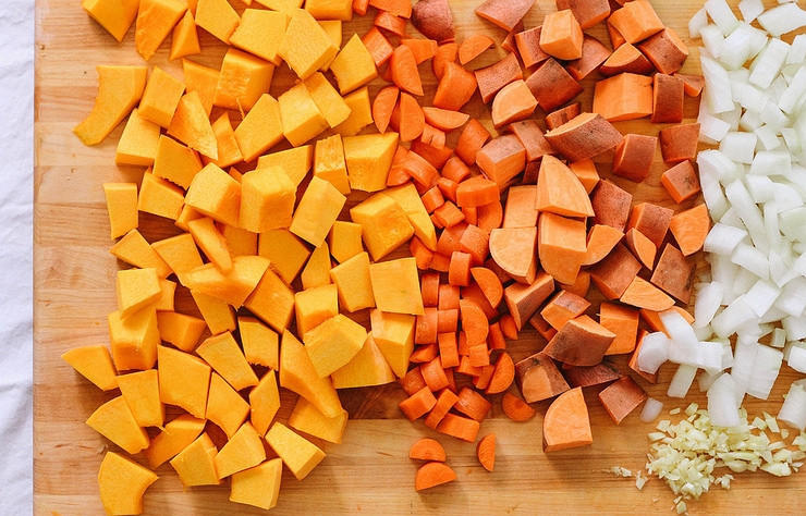 1. Этап. Рагу с нутом и тыквой: 2. Очистите и нарежьте полукольцами морковь, сладкий картофель - небольшими кусочками, а лук - кубиками. Измельчите чеснок.