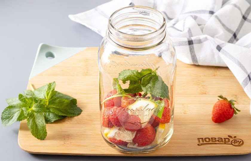 1. Этап. Компот из клубники, лимона и мяты на зиму: Выложите в чистую стерилизованную банку клубнику, лимон и мяту.