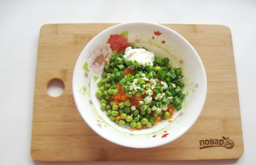 1. Этап. Салат с зеленым горошком и морковью: Салат посолите и поперчите по вкусу. Добавьте измельченный чеснок. Заправьте сметаной.
