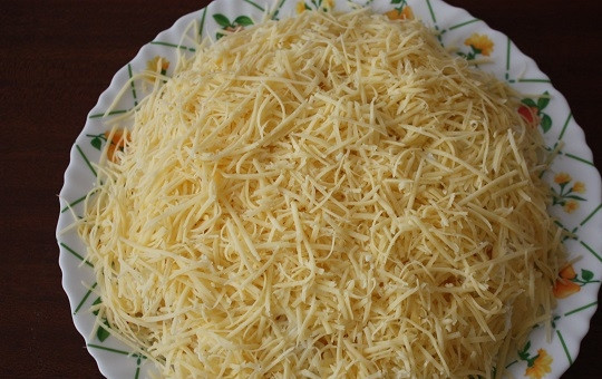 1. Этап. Салат с куриным филе и ананасами: 6. Смажьте майонезом. Натрите на терке сыр, присыпьте им сверху.