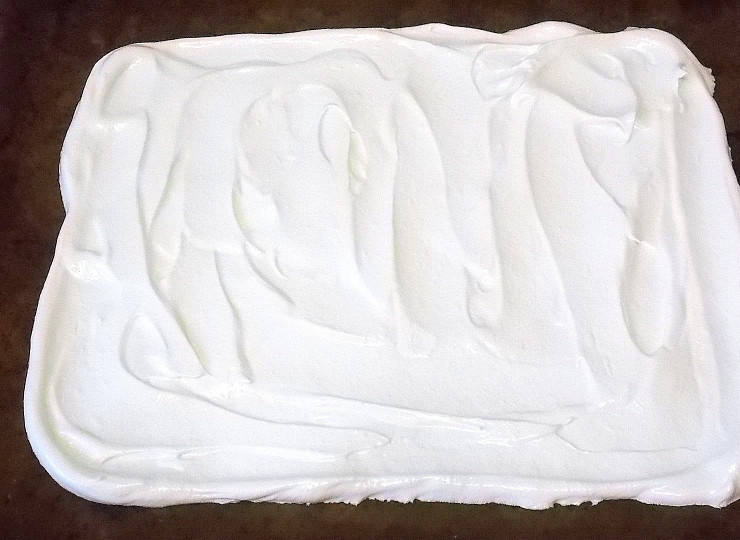 1. Этап. Меренговый рулет с малиной: Застелите противень бумагой для выпечки и разровняйте яичную массу в прямоугольник. Выпекайте в горячей духовке при 140 градусах в течение 35 минут. Выключите духовку, откройте дверцу и оставьте противень там до остывания.