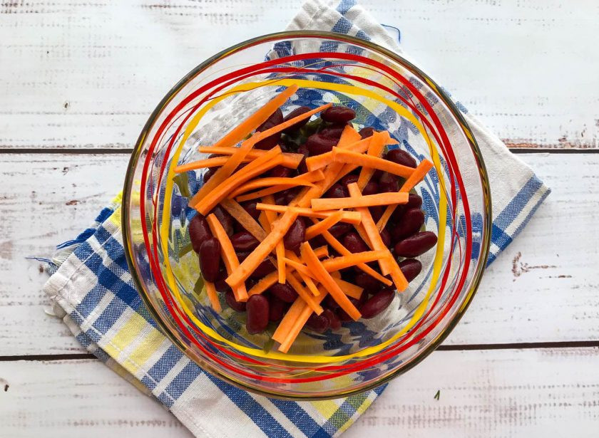 1. Этап. Салат с фасолью и морской капустой: Морковь помойте под проточной водой и нарежьте соломкой.