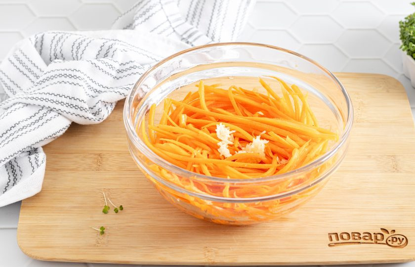 1. Этап. Морковь по-корейски домашняя с приправой: Зубчики чеснока очистите и пропустите через пресс. Добавьте к моркови.