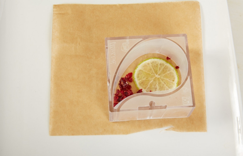 1. Этап. Шоколадный мусс с клюквой и лаймом: 5. На дно формы уложить срез лайма и посыпать мелко нарезанной сушенной клюквой.