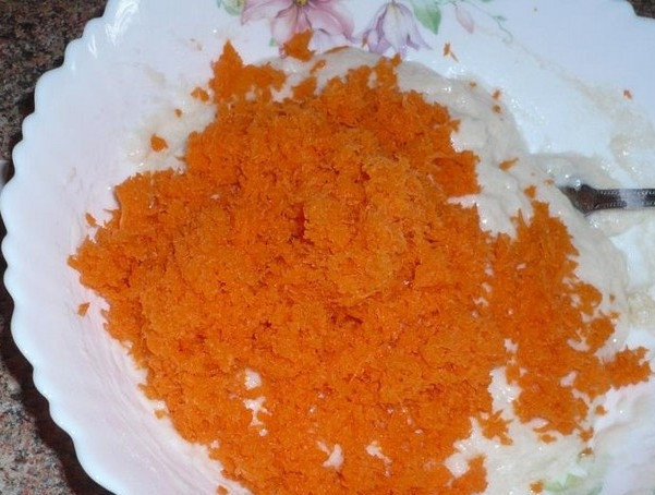 1. Этап. Морковный пирог постный: Морковь почистите, хорошо помойте и натрите на мелкой тёрке. Влейте в мучную массу воду, растительное масло. Добавьте морковь, соду, погашенную уксусом.