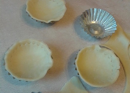 1. Этап. Закрытые тарталетки с курицей и грибами: Формочки смазываем растопленным маслом, вкладываем в них, распределяя по форме, большие заготовки из теста.