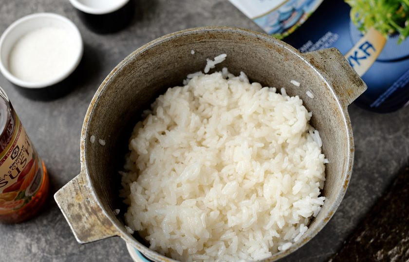 1. Этап. Роллы с чукой: Спустя время положите бумажные полотенца между казаном и крышкой, дайте постоять рису еще 15 минут. Затем влейте заправку, перемешайте. Отставьте рис в сторону остывать.