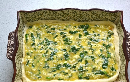 1. Этап. Пирог с фетой и шпинатом: Выложите тесто в форму для запекания, разровняйте. Вылейте начинку. Отправьте в разогретую до 180 градусов духовку.