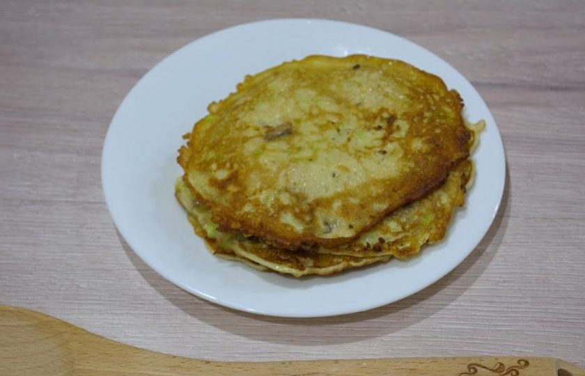 1. Этап. Блинчики из кабачков с грибами: 4. На разогретой сковороде, с добавлением растительного масла, обжарьте блинчики до готовности с двух сторон. На один блинчик идет по 2 ст. ложки блинной массы. Ее нужно распределить на сковороде ложкой в ровные, не очень толстый блинчик. Размер блинчика будет меньше чем сковорода.