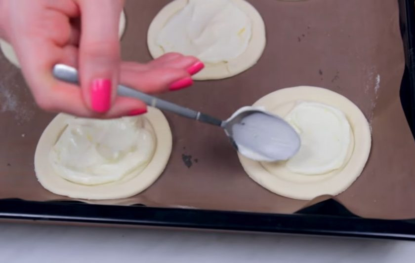 1. Этап. Слоеные пирожки на завтрак: 2. Приготовьте крем: сливочный сыр хорошо смешайте с сахаром, цедрой лимона, лимонным соком и ванилином. Нанесите крем с помощью ложки в центр каждого пирожка.