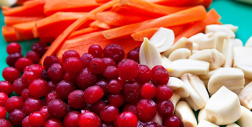 1. Этап. Окорок По-купечески: На следующий день подготовьте овощи и ягоды, которыми будем шпиговать окорок. Чеснок можете порезать (каждый зубчик — на половину), клюкву промойте, а морковку порежьте соломкой.