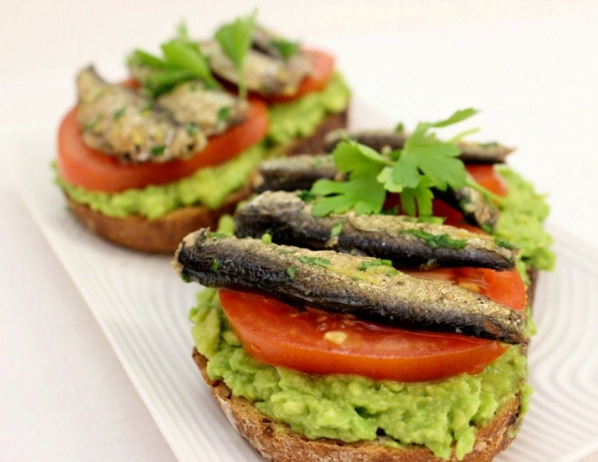 1. Этап. Бутерброды со шпротами и авокадо: Обжарьте хлеб, намажьте полученное пюре из авокадо, положите ломтик помидора, сверху положите пару сардин, украсьте петрушкой и сбрызните лимонным соком.