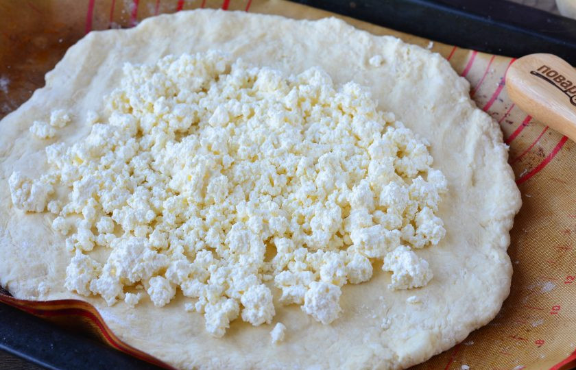 1. Этап. Галета с яблоками и творогом: Затем тесто тонко раскатайте и придайте форму круга. В центр выложите творог и распределите начинку, не доходя до края.