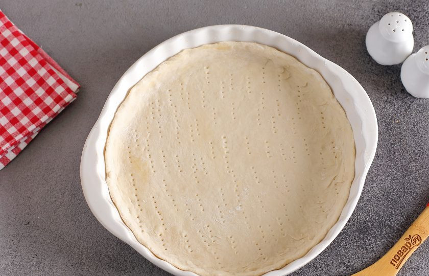 1. Этап. Восточная пицца: Подошедшее тесто разделите на 4 или 6 частей, в зависимости от желаемого размера пиццы. Каждый кусок раскатайте в форме круга, толщиной 2-3 мм. и переложите в смазанную маслом форму или на противень. Тесто наколите вилкой.