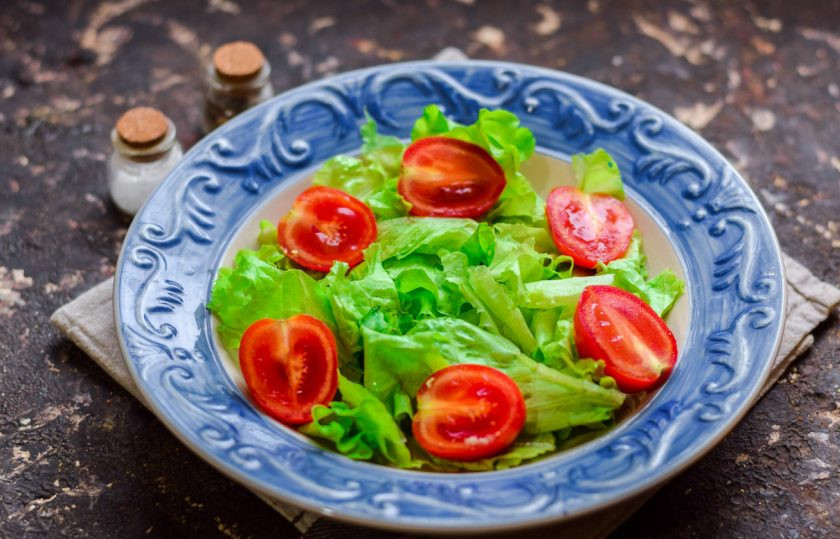 1. Этап. Салат Цезарь с индейкой: На тарелку выложите чистые салатные листья, порванные руками. Добавьте половинки черри.