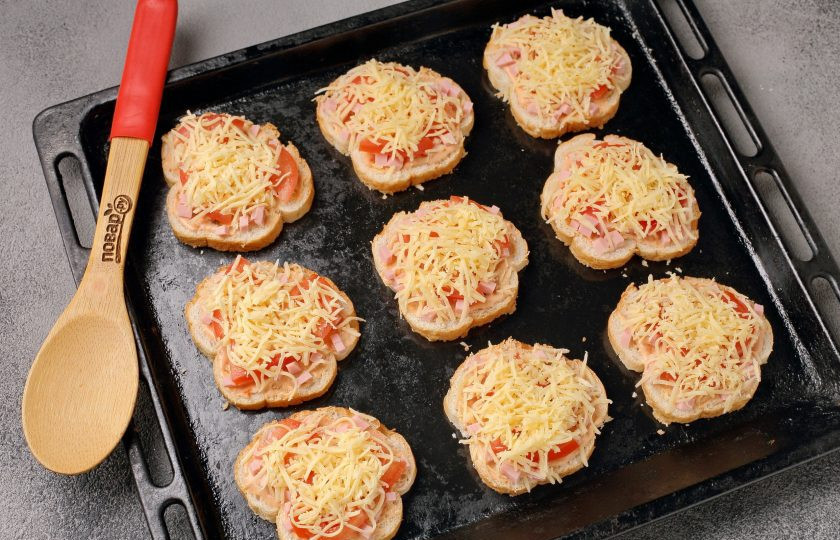 1. Этап. Мини-пицца на батоне в духовке: Переложите заготовки на противень и запеките в духовке при температуре 180 градусов в течение 10-15 минут.