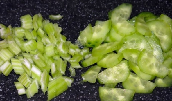 1. Этап. Салат из свежей капусты и огурцов: Стебли сельдерея измельчаем. Огурец очищаем от кожуры и нарезаем кружочками, а затем еще раз пополам.