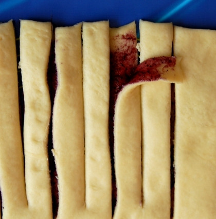 1. Этап. Пирожки с черникой: Каждую полоску следует разрезать таким образом: начиная со свободного края и оставляя примерно один сантиметр до места сгиба, разрезать тесто посередине.