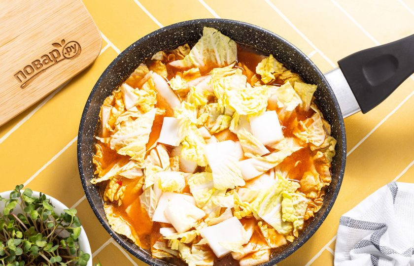 1. Этап. Рисовые токпокки: Нарежьте кубиками пекинскую капусту и добавьте в сковороду. Потушите капусту 4-5 минут до мягкости на среднем огне.